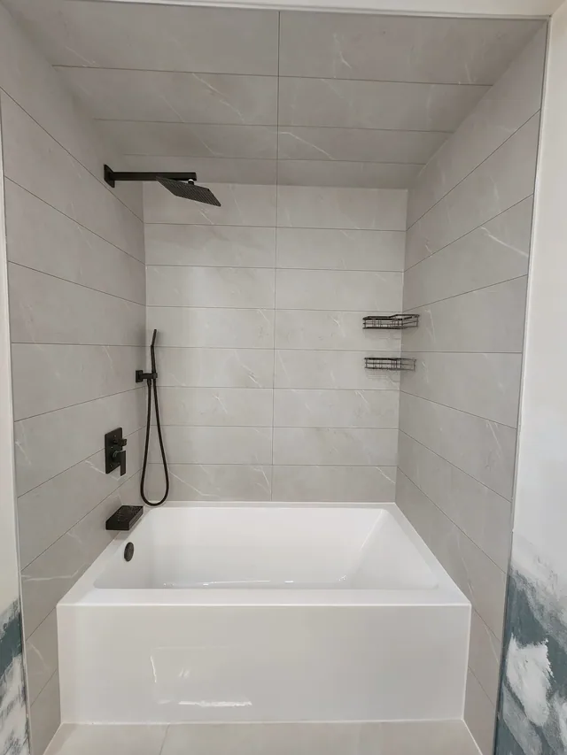 New acrylic bathtub with grey marble-look tile-less walls, Calgary