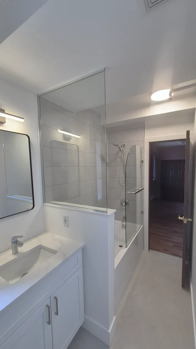 Completed full bathroom renovation with vanity and glass panel, Calgary